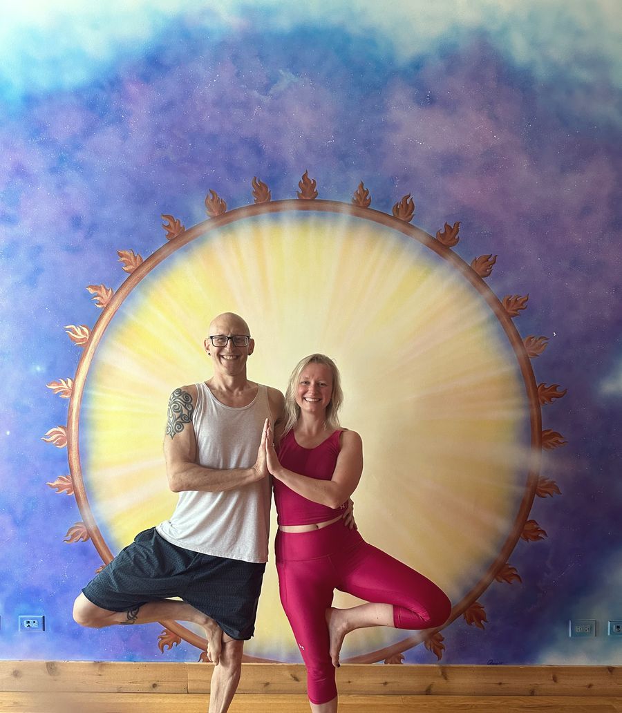 Rich and a fellow yogi in tree pose in front of the painted sun mural at Chi Yoga Shack